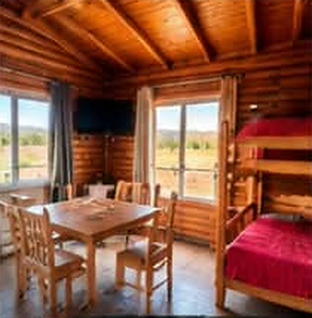 Comedor y dormitorio de una cabaña del Complejo E.Dén